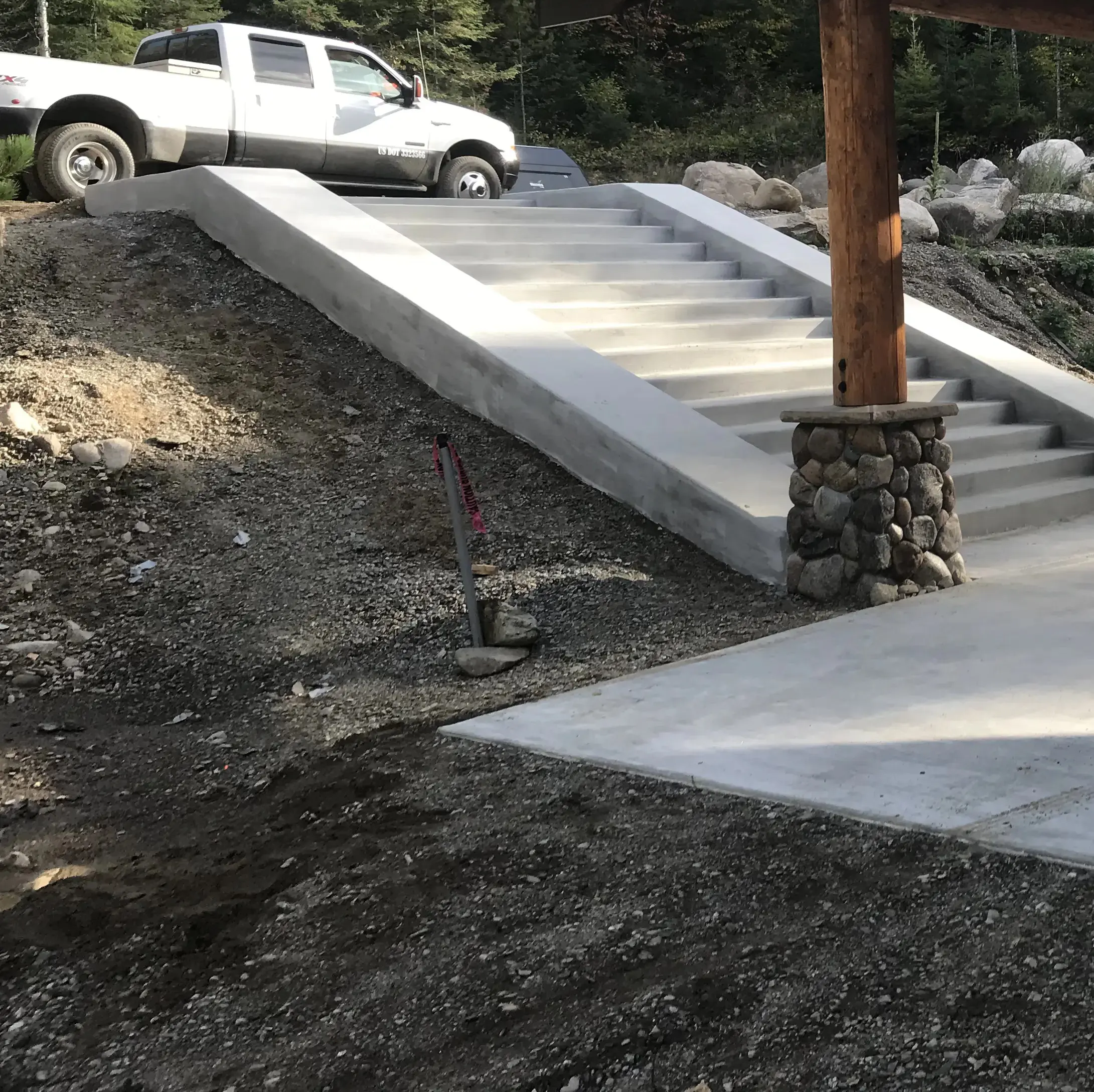 A new home being constructed with rock work done on the pillars, and a rock staircase.